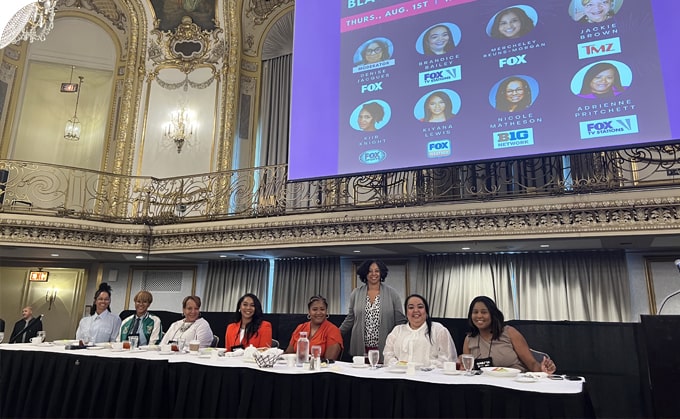 Eight diverse FOX employees standing in the FOX office